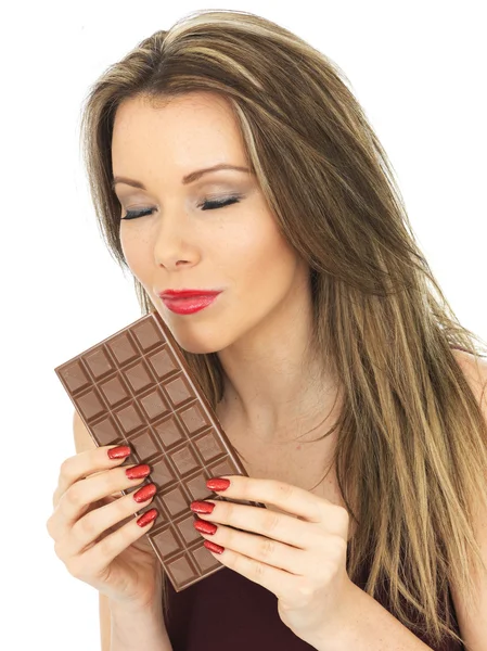 Giovane donna che tiene una tavoletta di cioccolato al latte — Foto Stock