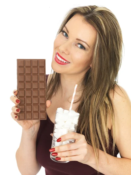 Giovane donna Confrontando una tavoletta di cioccolato con un bicchiere di zucchero — Foto Stock