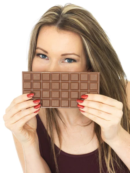 Молодая женщина держит шоколадный батончик — стоковое фото