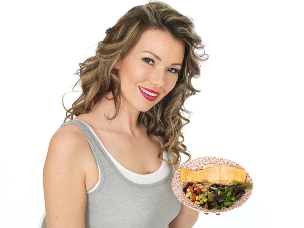 Jovem mulher comendo salmão e salada de feijão — Fotografia de Stock