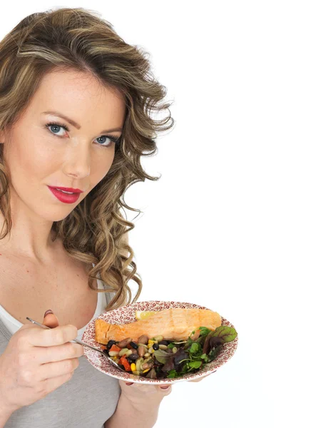 Jovem mulher comendo salmão e salada de feijão — Fotografia de Stock