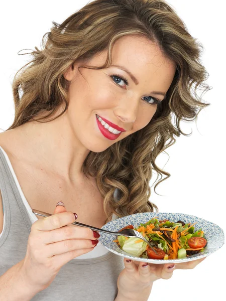 Mujer joven comiendo una ensalada mixta de jardín fresco — Foto de Stock