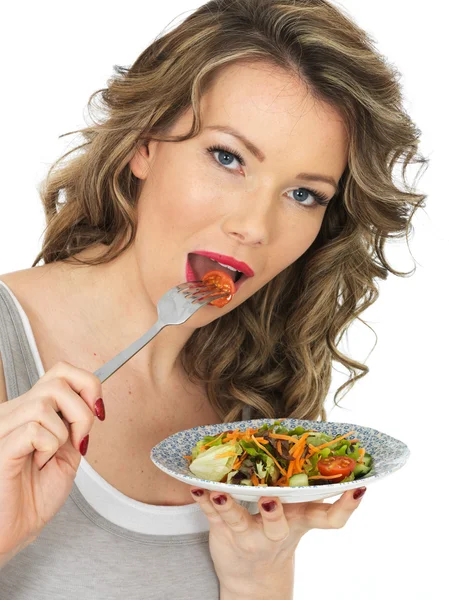 Junge Frau isst einen frischen gemischten Gartensalat — Stockfoto