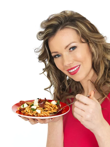 Junge Frau isst Feta-Käse und Tomaten-Nudelsalat — Stockfoto