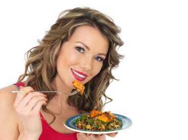 Genç kadın bir tavuk Tikka ve pirinç salatası yemek