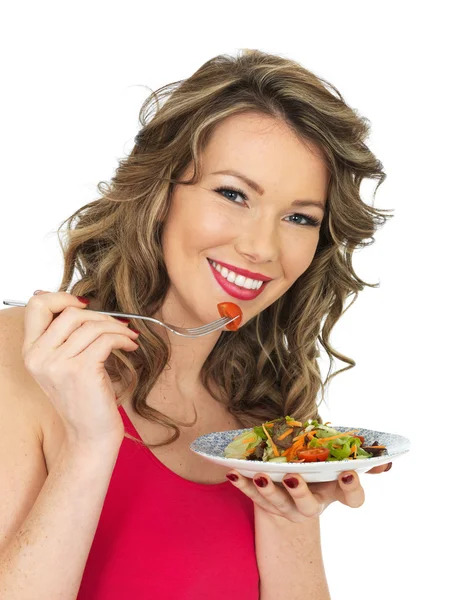 Junge Frau isst frischen, knusprigen Gartensalat — Stockfoto