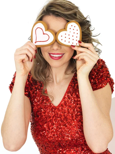 Joven sosteniendo galletas de jengibre de San Valentín — Foto de Stock