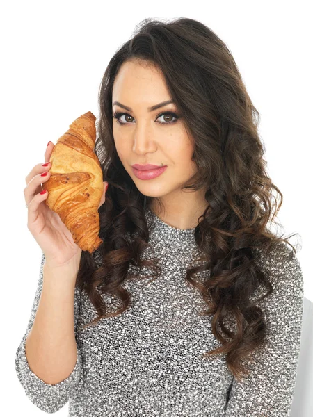 Jonge vrouw met een croissant — Stockfoto