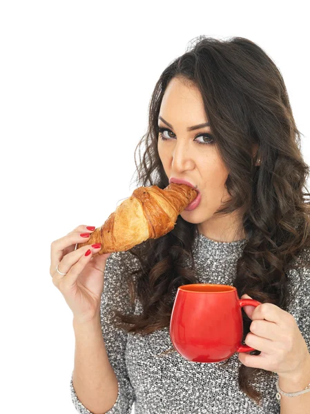 Jovem mulher desfrutando de chá e croissants — Fotografia de Stock
