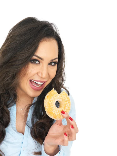 Молодая женщина наслаждается пончиком с сахарным покрытием — стоковое фото