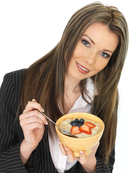 Joven mujer de negocios comiendo un tazón de gachas con fruta fresca —  Fotos de Stock