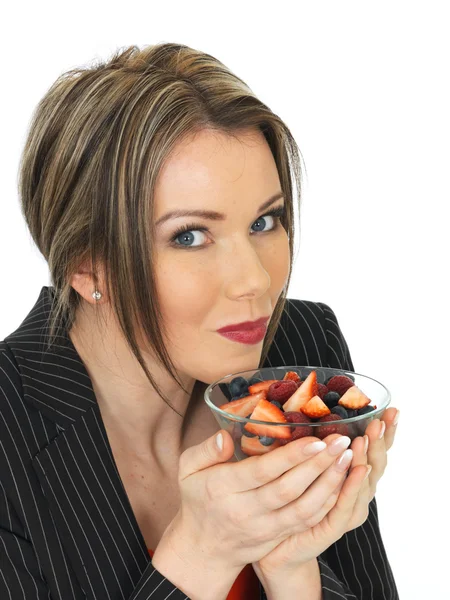 Joven mujer de negocios sosteniendo un tazón de frutas frescas bayas — Foto de Stock