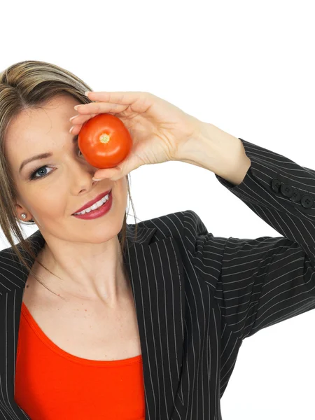Joven mujer de negocios sosteniendo un tomate crudo —  Fotos de Stock