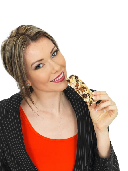 Jonge zakenvrouw eten een ontbijtbar granen — Stockfoto
