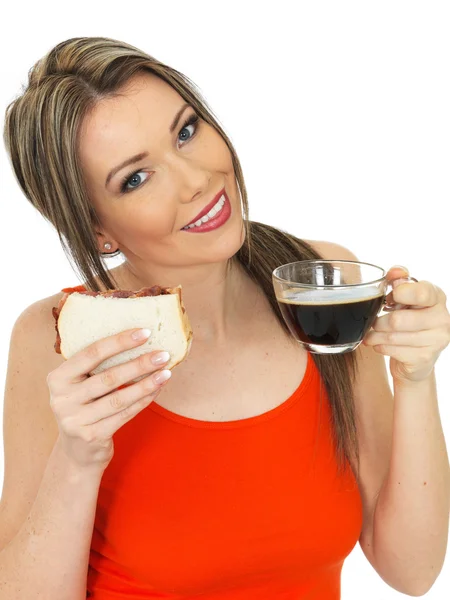 Junge Frau mit schwarzem Kaffee und Specksandwich — Stockfoto