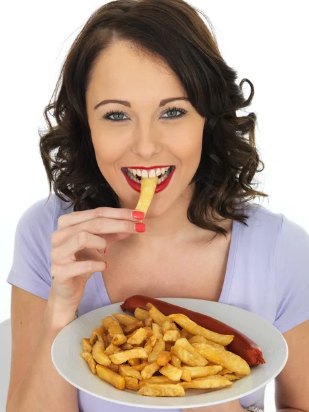 Mujer joven comiendo Saveloy y patatas fritas —  Fotos de Stock