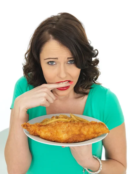 Mujer joven comiendo pescado tradicional y patatas fritas — Foto de Stock