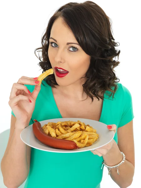 Mujer joven comiendo salchichas Saveloy y patatas fritas —  Fotos de Stock