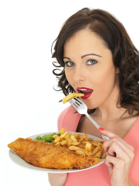 En sevdiği balık ve bezelyeli patates kızartmasını yiyen genç bir kadın. — Stok fotoğraf