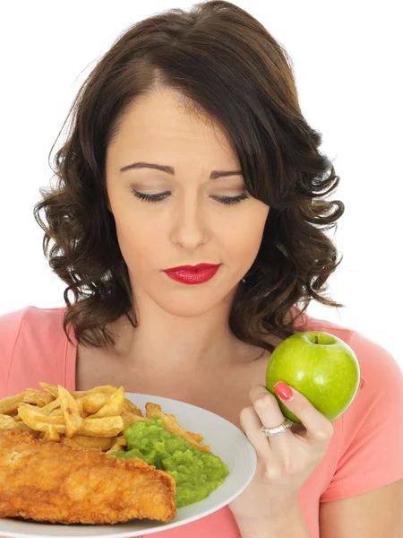 Mujer joven comiendo pescado y patatas fritas con guisantes — Foto de Stock