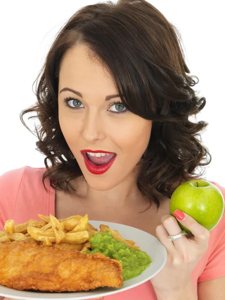 Jovem mulher comer peixe e batatas fritas com ervilhas Mushy — Fotografia de Stock