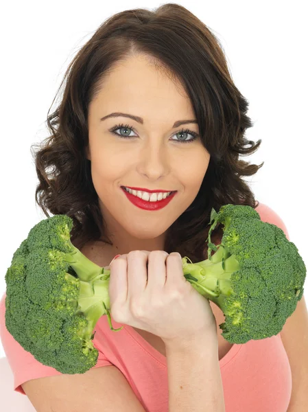 Junge Frau hält rohen Brokkoli in der Hand — Stockfoto