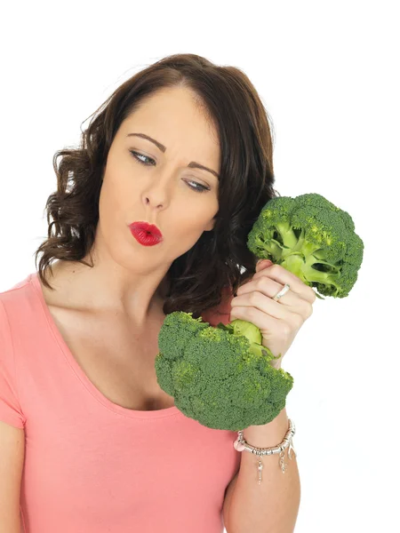 Mujer joven sosteniendo brócoli crudo — Foto de Stock