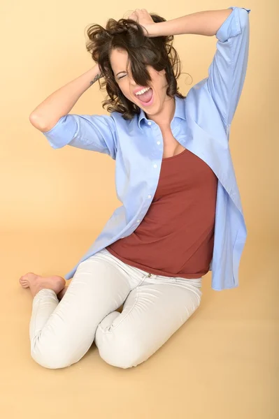 Jovem mulher sentada no chão vestindo uma camisa azul e branca — Fotografia de Stock