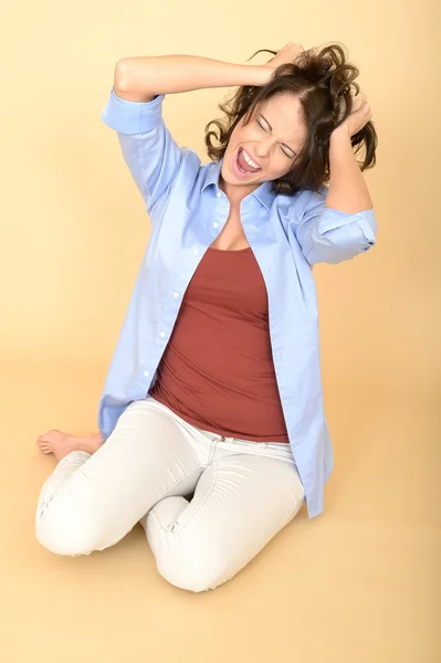 Giovane donna seduta sul pavimento con una camicia blu e bianco — Foto Stock