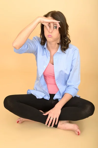 Joven mujer loca sentada en el suelo con una camisa azul y —  Fotos de Stock