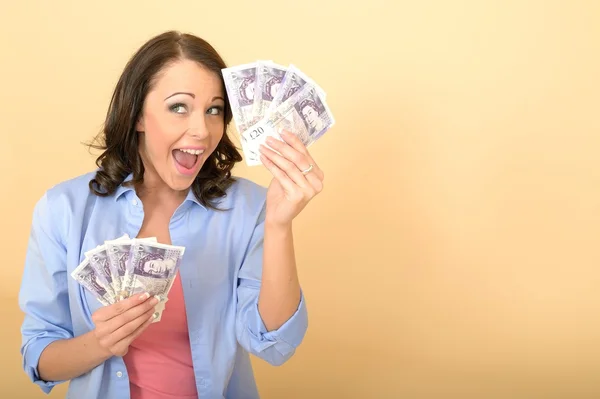 Молодая счастливая женщина, держащая деньги, выглядит довольной и довольной — стоковое фото