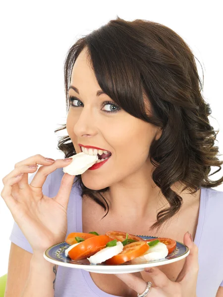 Młoda kobieta jedzenie sera Mozzarella i sałatka z pomidorów — Zdjęcie stockowe