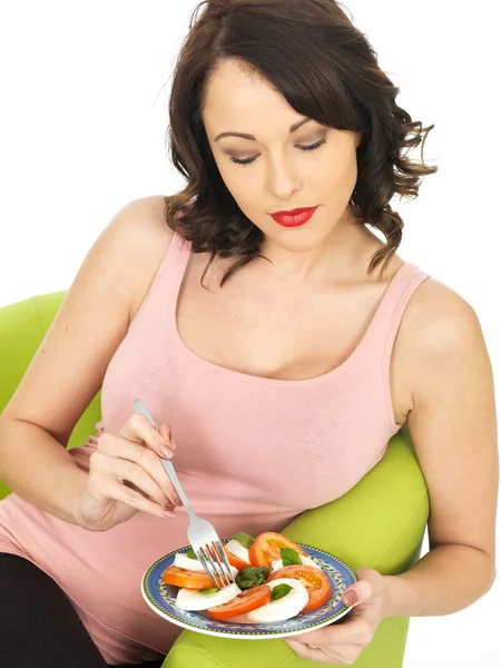 Junge Frau isst Mozzarella und Tomatensalat — Stockfoto