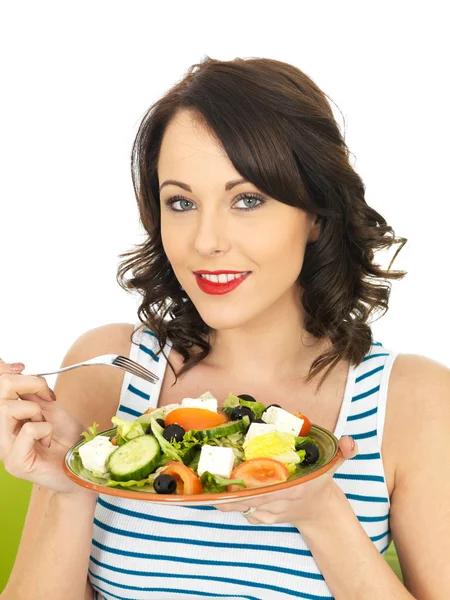 Fiatal nő eszik egy friss, ropogós, görög saláta — Stock Fotó