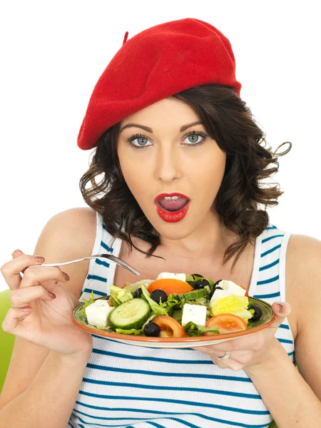Genç kadın bir taze çıtır Yunan salata yemek — Stok fotoğraf