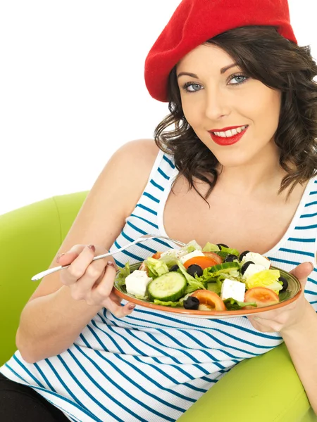 Mujer joven comiendo una ensalada griega crujiente fresca — Foto de Stock