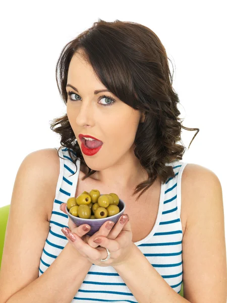 Jovem mulher comendo azeitonas verdes — Fotografia de Stock