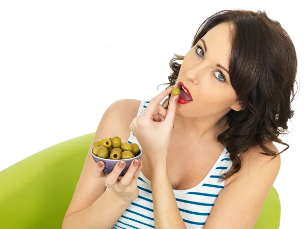 Jeune femme mangeant des olives vertes — Photo