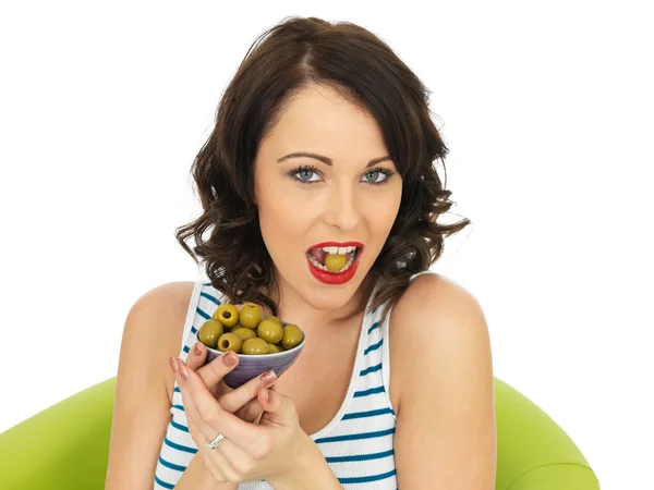 Mladá žena jíst zelené olivy — Stock fotografie