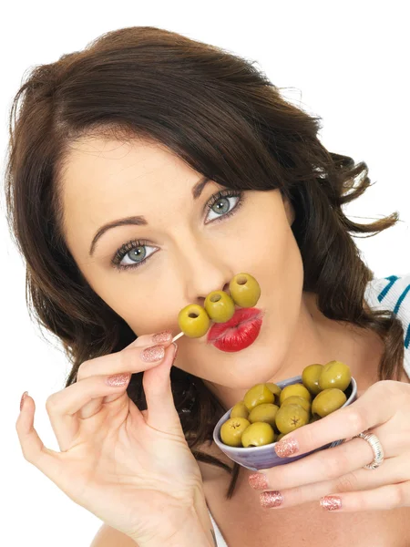 Jeune femme mangeant des olives vertes — Photo