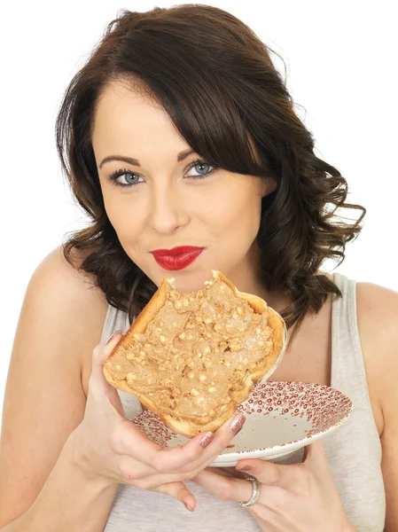 Mujer joven sosteniendo tostadas con mantequilla de maní crujiente —  Fotos de Stock