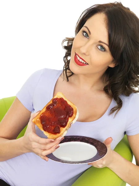 Mujer joven con mermelada de fresa en tostadas — Foto de Stock