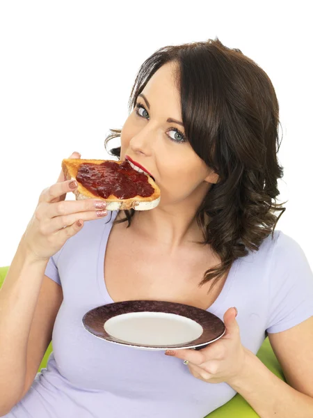 Junge Frau mit Erdbeermarmelade auf Toast — Stockfoto