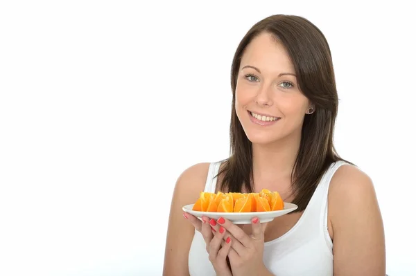 Gesunde junge Frau bei der Diät, hält einen Teller mit frischen Orangensegmenten in der Hand — Stockfoto