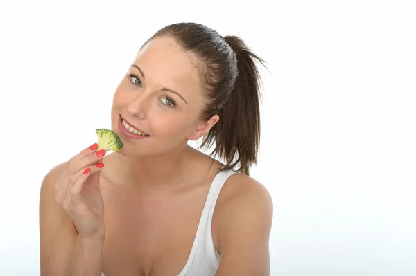 Привлекательная молодая женщина ест сырую брокколи — стоковое фото
