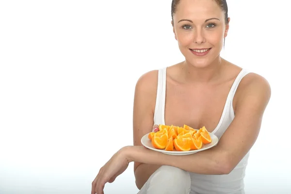 Attrayant jeune femme tenant une assiette de coupe fraîche mûre oranges saines — Photo