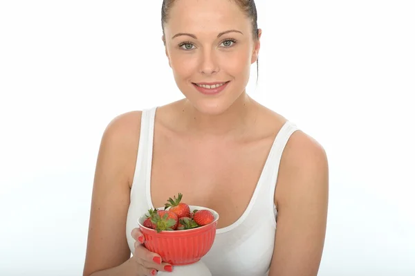 Mujer joven sana en forma sosteniendo un tazón de fresas jugosas frescas maduras —  Fotos de Stock