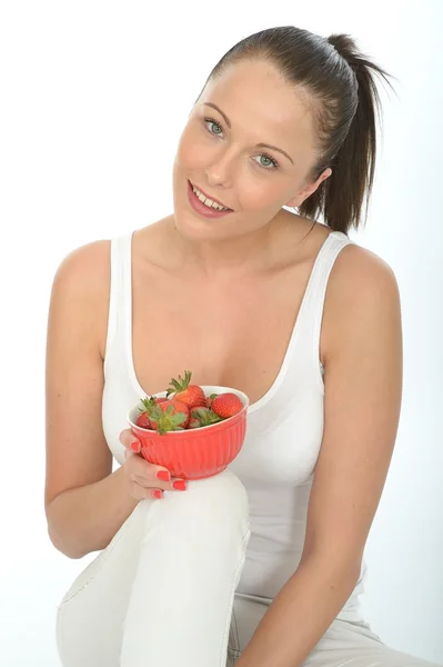 Mujer joven sana en forma sosteniendo un tazón de fresas jugosas frescas maduras — Foto de Stock
