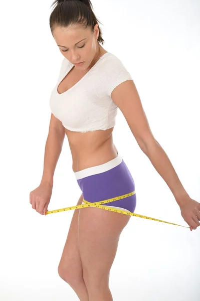 Friska unga kvinnan kontrollera hennes viktminskning med ett måttband — Stockfoto