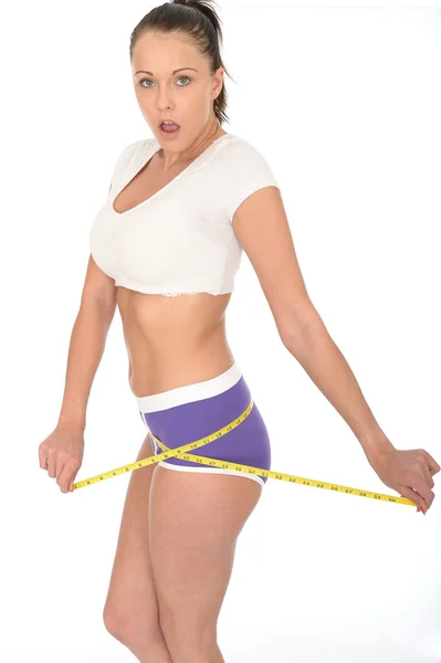 Gesunde junge Frau überprüft ihren Gewichtsverlust mit einem Maßband — Stockfoto